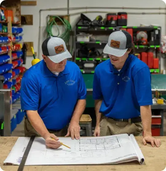 Anytime Heating and Cooling Technicians looking at plans on a table